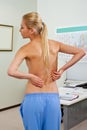 Topless female patient back pain