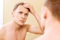 Topless man fixing hair in front of mirror Royalty Free Stock Photo