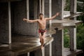 Topless man walking on a slackline on rainy day