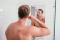 Topless muscle man brushing his teeth front of mirror Royalty Free Stock Photo
