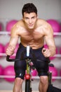 Topless Muscular Man Spinning Gym Bike Royalty Free Stock Photo