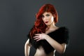 Topless redhead woman covering her breasts with a black fur coat Royalty Free Stock Photo