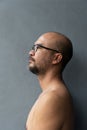 Topless 40s beard bald Asia man portrait on grey wall