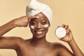 Topless woman in hair turban using moisturizer on her skin. Royalty Free Stock Photo