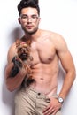 Topless young man poses with puppy