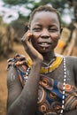 TOPOSA TRIBE, SOUTH SUDAN - MARCH 12, 2020: Young woman with traditional scars of Toposa Tribe touching face and looking at camera