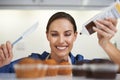 Topping off her cupcakes. A happy young woman about to apply frosting to her freshly-baked batch of cupcakes. Royalty Free Stock Photo