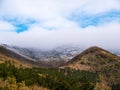 Tops of mountains in low thick clouds and trees covered with hoarfrost, morning hills panorama