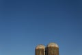 Tops of two old grain silos against a deep blue sky, copy space