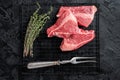 Topside sirloin beef cut, raw meat with spices. Black background. Top view