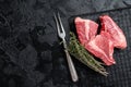 Topside sirloin beef cut, raw meat with spices. Black background. Top view. Copy space