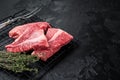 Topside sirloin beef cut, raw meat with spices. Black background. Top view. Copy space