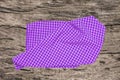 Topview of empty violet checkered kitchen cloth, textile, tablecloth or napkin on a blurred rustic wooden background. Template for Royalty Free Stock Photo