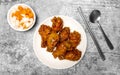 Top view Korean spicy deep-fried chicken topped white sesame with pickled carrot and pickled radish side dishes on the gray concr