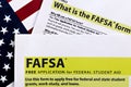 Topview photo of FAFSA - free application for federal student aid, on a background of United States flag