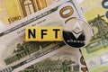 Topview photo on NFT non-fungible token theme. Abbreviation NFT and Ethereum blockchain cryptocurrency coin, on the background