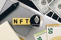 Topview photo on NFT non-fungible token theme. Abbreviation NFT and Ethereum blockchain cryptocurrency coin, on the background