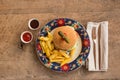 Hamburger with french fries in plate with ornaments