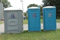 tor, canada - July 16, 2023: three porta portable potties next to each other on grass, one gray and two blue. p