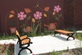 tor, canada - July 16, 2023: two benches facing each other on pavement cement with pink flower mural on brick. p