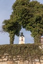 Torbogen mit Efeu auf alter Steinmauer und Kirchturm Royalty Free Stock Photo
