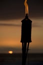 Torch on the beach at sunset. Royalty Free Stock Photo