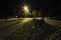 A torch-light inundates a nightly snow bound road on the outskirts of small town. Royalty Free Stock Photo