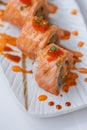 Torched Salmon Maki Sushi with Shrimp Tempura, Avocado and Cheese inside. Topping with Sauce, Ebiko Shrimp Egg and Scallion Royalty Free Stock Photo