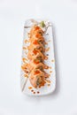 Torched Salmon Maki Sushi with Shrimp Tempura, Avocado and Cheese inside. Topping with Sauce, Ebiko Shrimp Egg and Scallion Royalty Free Stock Photo