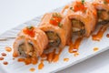 Torched Salmon Maki Sushi with Shrimp Tempura, Avocado and Cheese inside. Topping with Sauce, Ebiko Shrimp Egg and Scallion Royalty Free Stock Photo