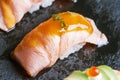 Torched Salmon Sushi with Sauce Served on Black Stone Plate.