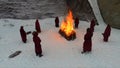 Torchlight procession. Ritual fire. Footage. Group of monks in hood robe walking along winter snow trail in forest