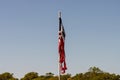 Torn American flag hanging from pole