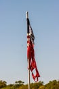 Torn American flag hanging from pole