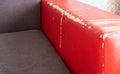 Torn and battered leather back of the sofa. Poor quality leather, leather cleansing and restoration