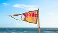 Torn beach flag and sea behind