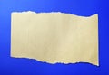 Torn beige crumpled kraft paper lies on a blue paper background. Royalty Free Stock Photo