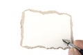 Torn blank cardboard paper with the hand and the pen. Royalty Free Stock Photo