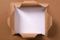 Torn brown paper square hole background frame white behind