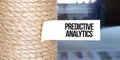 Torn brown paper on white surface with text PREDICTIVE ANALYTICS Royalty Free Stock Photo