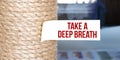 Torn brown paper on white surface with text Take a deep breath Royalty Free Stock Photo