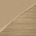 Torn brown texturing paper over a wooden plank wall. Royalty Free Stock Photo