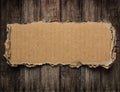 Torn cardboard on wood background