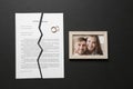 Torn divorce decree, rings and broken frame with photo on dark background Royalty Free Stock Photo