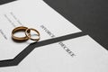 Torn divorce decree with rings on dark background Royalty Free Stock Photo