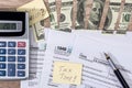 Torn dollars on tax form, pen and calculator Royalty Free Stock Photo