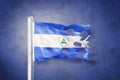 Torn flag of Nicaragua flying against grunge background Royalty Free Stock Photo