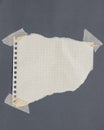 Torn graph paper with adhesive tape, scraps of paper on sticky tape, gray background