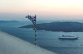 Torn Greek flag along the sunset coast with cruise ship in Fira, Santorini, Greece Royalty Free Stock Photo