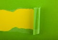 Torn green paper isolated on yellow background